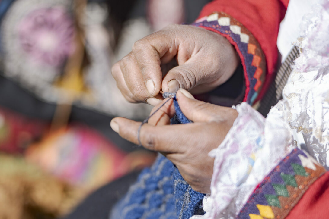 Hände einer Teilnehmerin von APEDIK in Peru beim Weben.