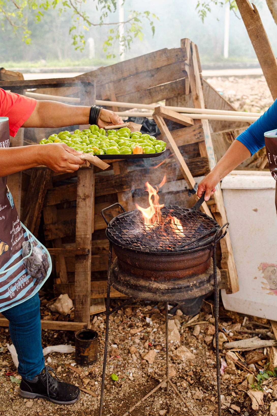 Chilis werden über dem Feuer geröstet und danach weiterverarbeitet.