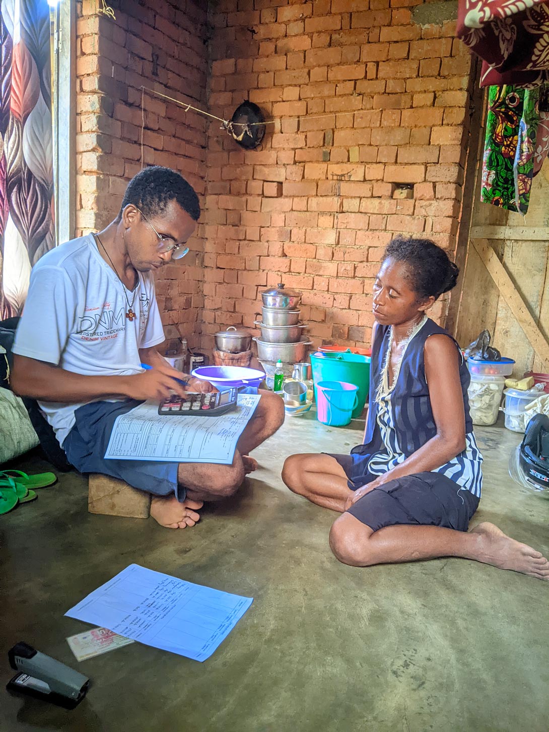 Teilnehmerin einer Mikrokreditgruppe von Mampita in Madagaskar erhält Beratung bei einem Hausbesuch.