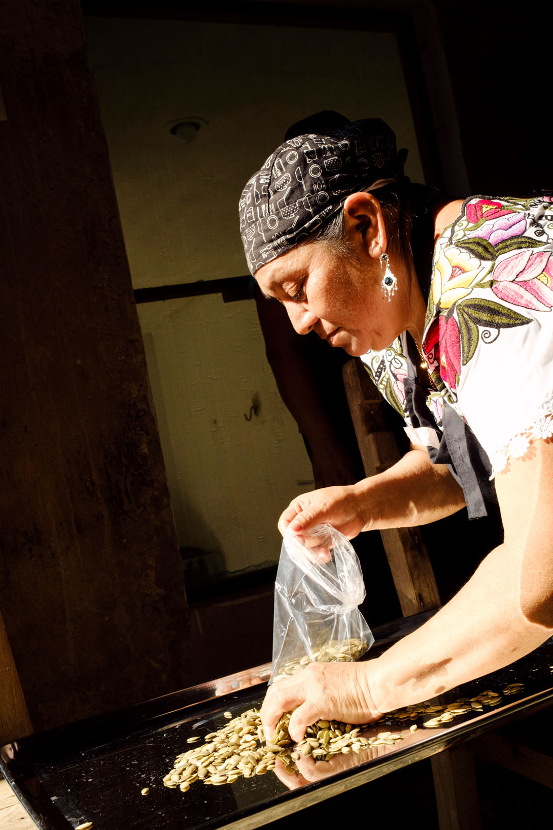 Eine Teilnehmerin von HST in Mexiko sammelt Kürbiskerne in einem Beutel.