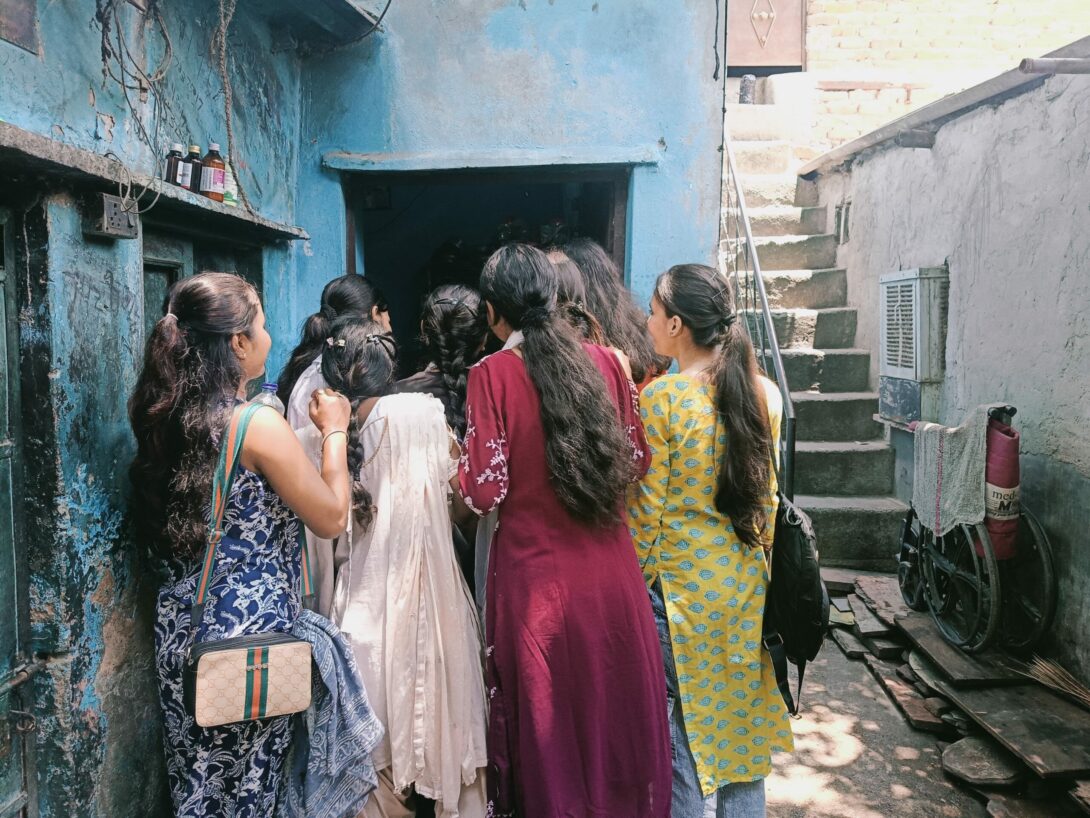 Eine Gruppe von Teilnehmerinnen eines FAT Projekts in Indien schauen durch eine Tür.