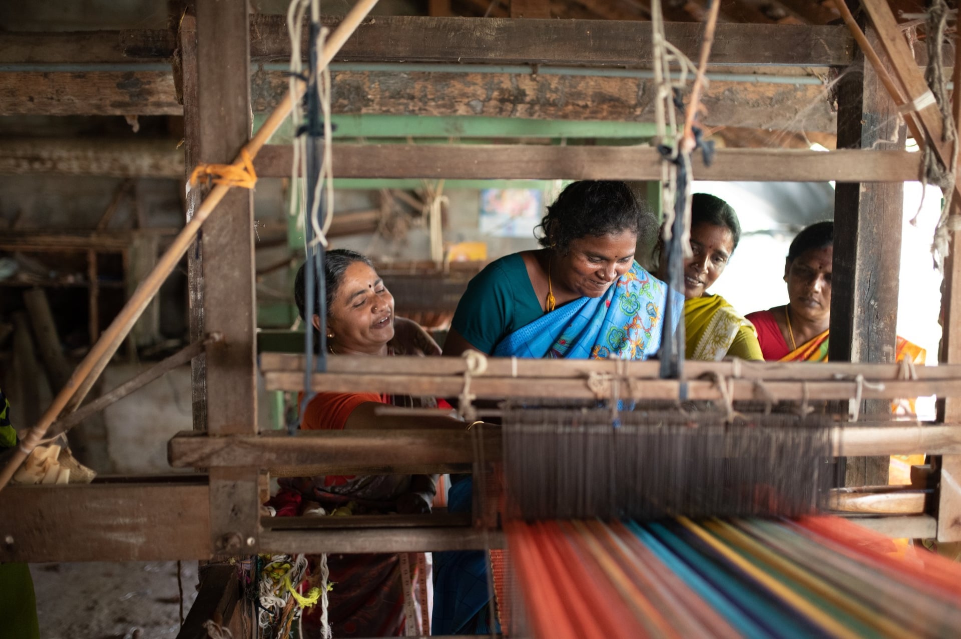 Projektteilnehmerinnen von RWDT in Indien lernen, einen Webstuhl zu benutzen.