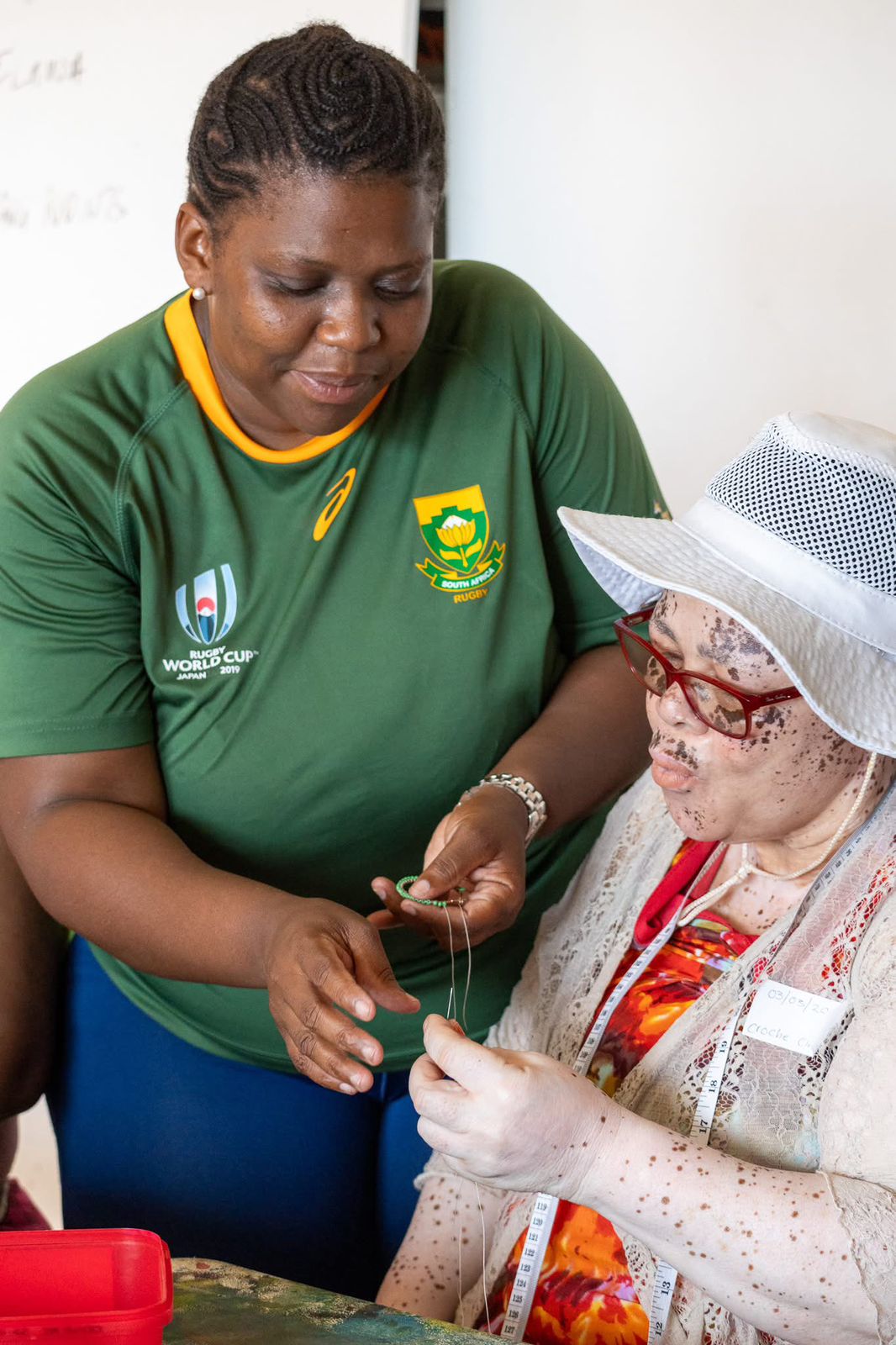 Die Unternehmerin Thulisa Mphathiswa leitet einen Perlenstickerei-Workshop für Frauen aus der Gemeinde.
