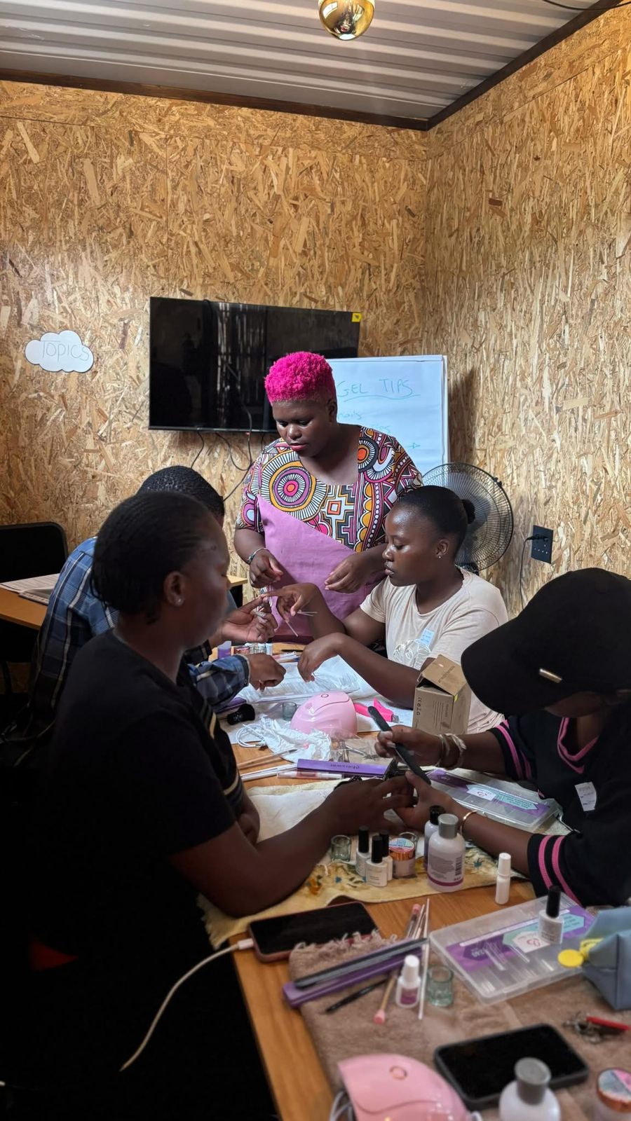 Unternehmerin Zimasa Maqashalala leitet einen Nageltechnik-Workshop für von Arbeitslosigkeit betroffene Jugendliche aus der Region.