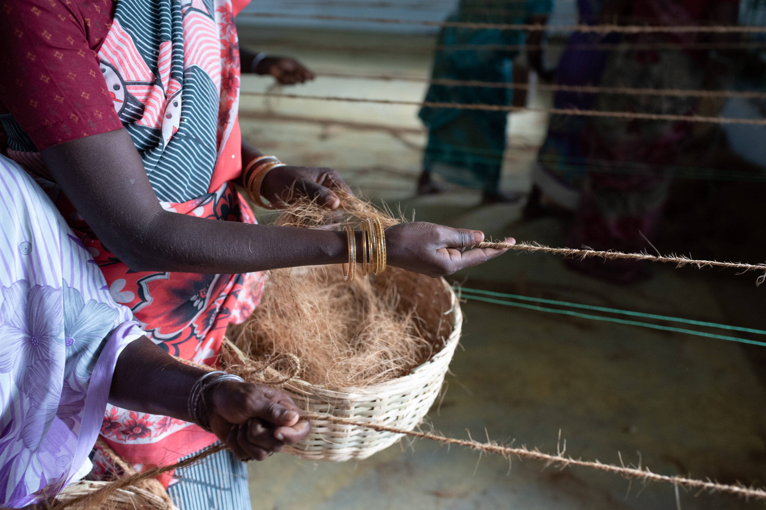 Projektteilnehmerinnen der Organisation RWDT in Indien spinnen Kordeln aus Kokosfasern.